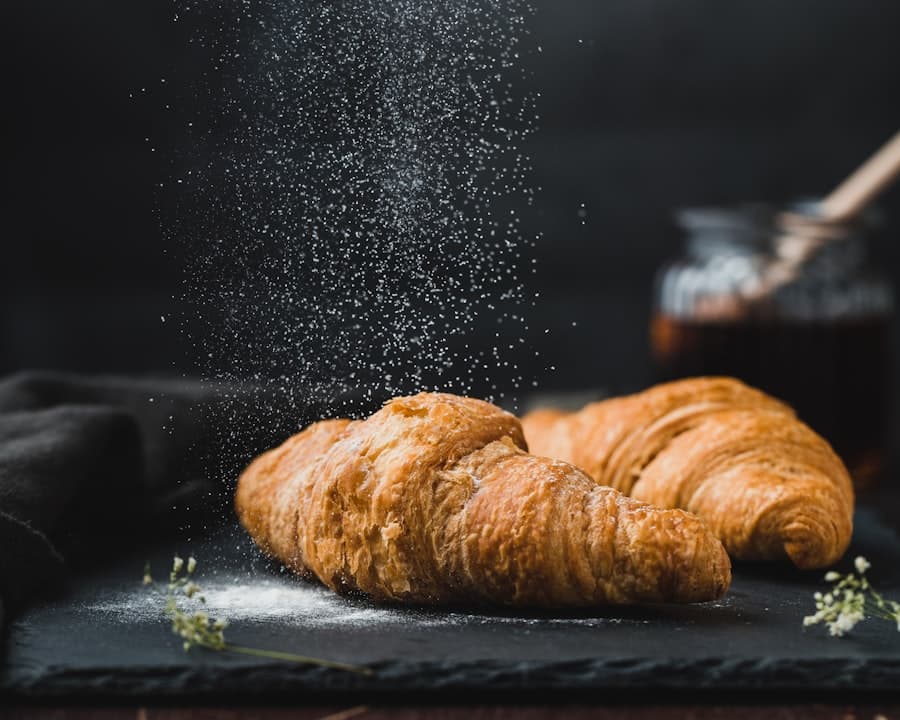 Croissants au beurre saupoudrés de sucre glace à la sortie du four