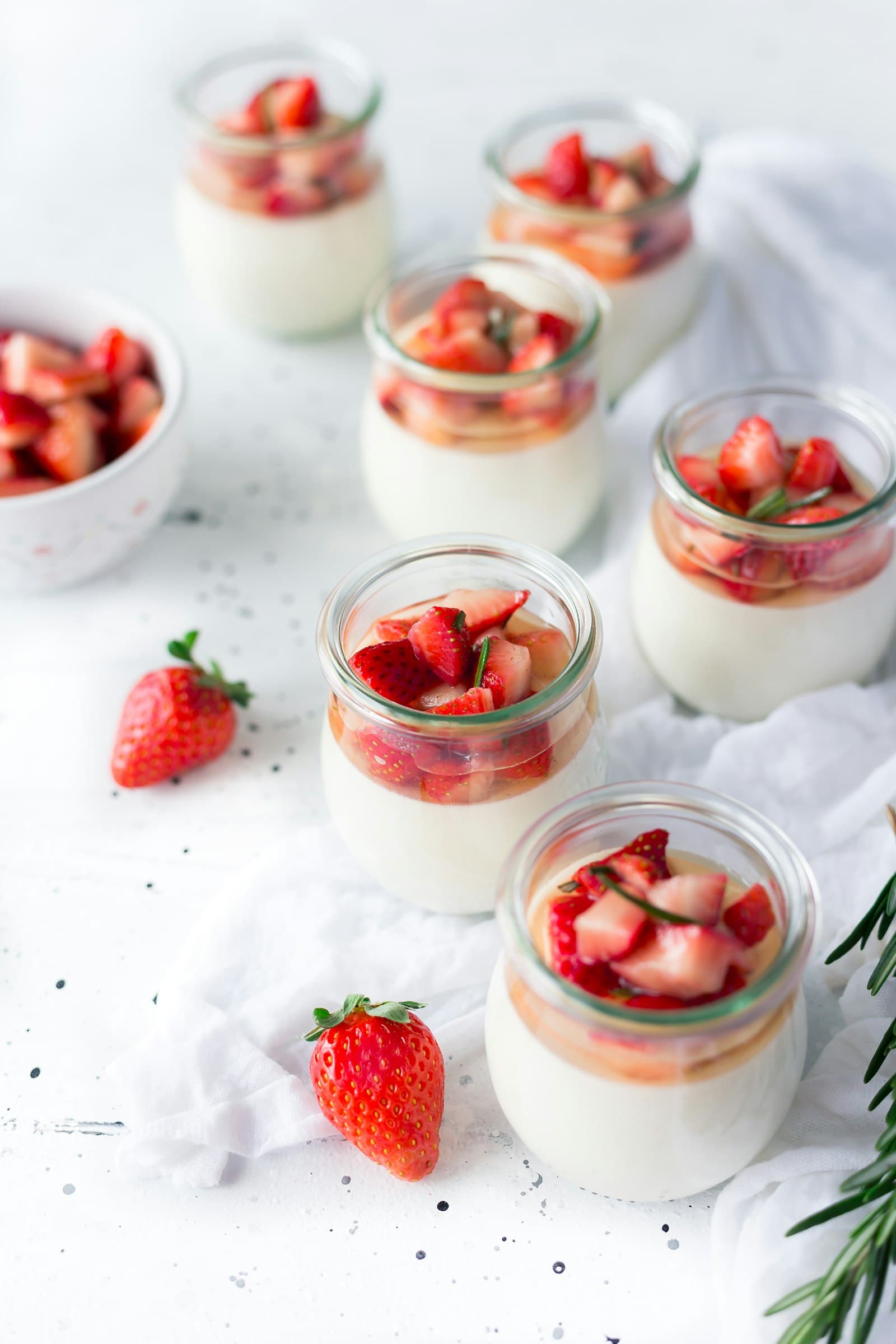 Verrines de crème aux fraises alignées sur la table de la vitrine