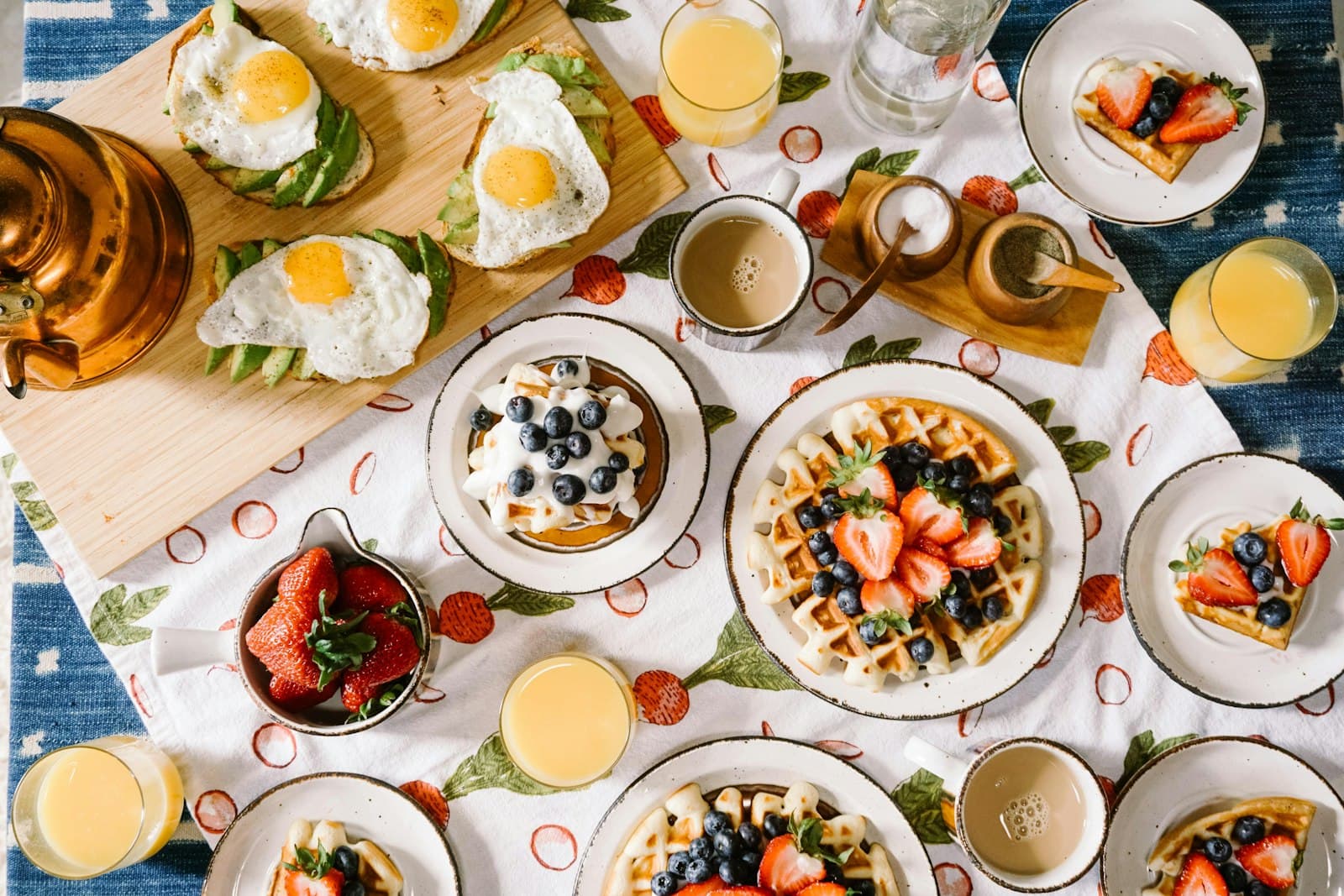 Table de petit-déjeuner garnie de gaufres, fruits rouges et jus d'orange