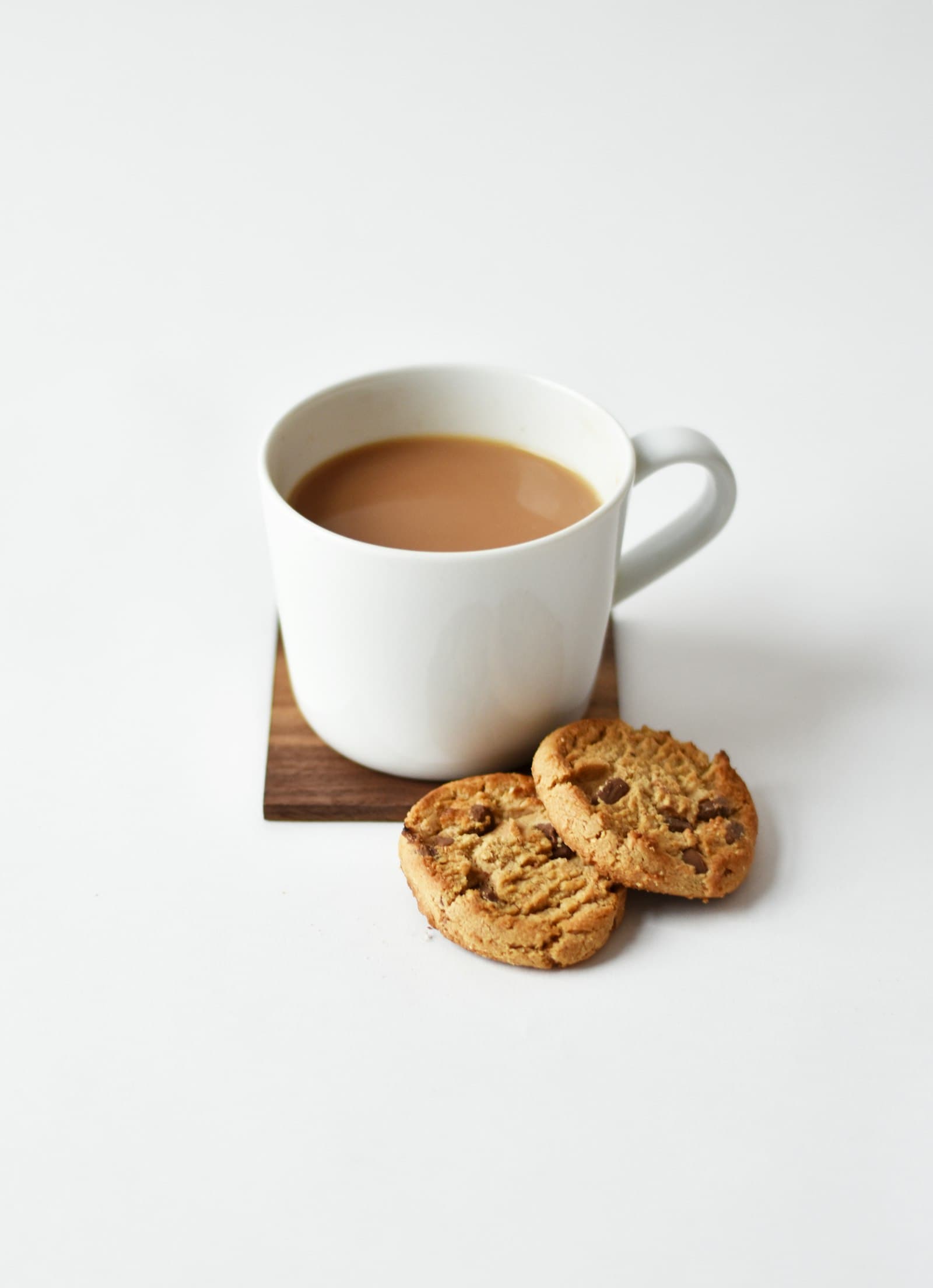 Tasse de thé au lait accompagnée de deux sablés aux pépites de chocolat